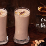 Two glasses of milk with nuts and a jar